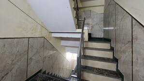 A marble staircase with metal railings, leading to an upper floor. - Hotel Step Inn Gold (New Delhi)