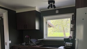 A modern kitchen with dark wood cabinets, a built-in oven, a stainless steel sink, and a window overlooking a garden. - Live in a scenic location, close to hiking trails or cozy cafés (Västra Götalands län)