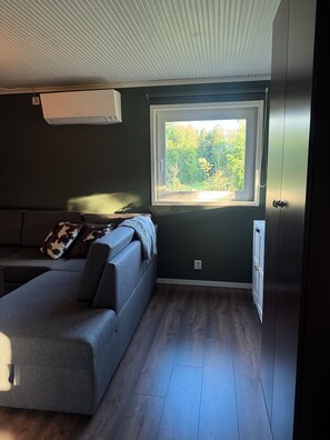 Une pièce dotée d’une fenêtre intégrée, d’un canapé, d’une armoire et d’un ventilateur de plafond.