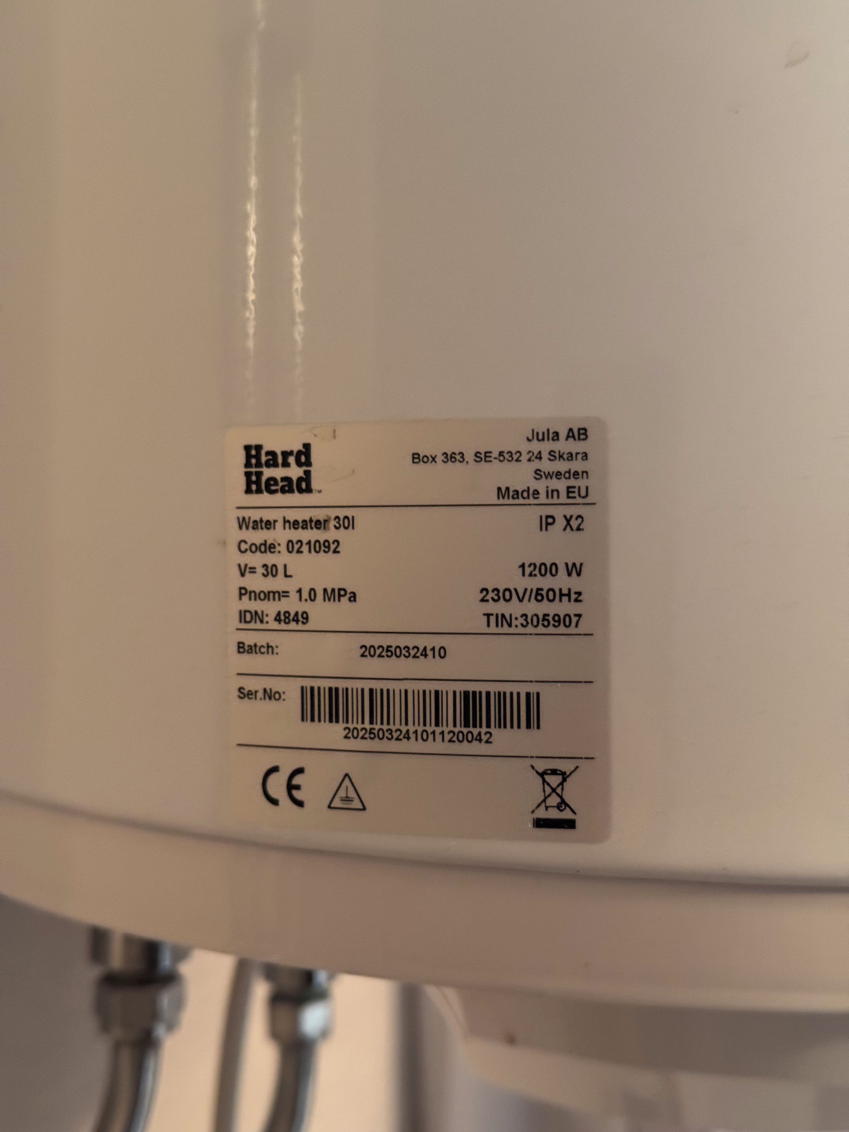 Etiqueta en un calentador de agua con especificaciones técnicas y un código de barras.