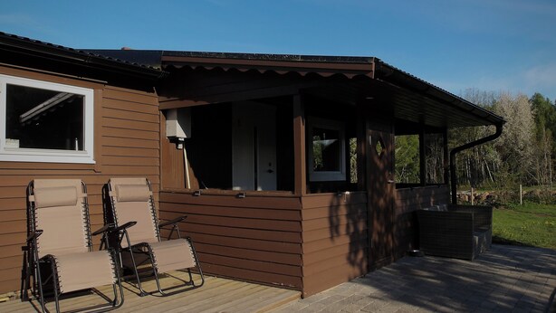 A wooden cabin with a covered porch, two folding chairs, and a window. - Live in a scenic location, close to hiking trails or cozy cafés (Västra Götalands län)