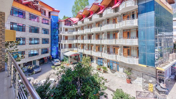 Un hôtel à plusieurs étages doté de balcons, d’un restaurant situé au rez-de-chaussée et d’un espace de stationnement.