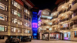 Un hôtel à plusieurs étages, doté d’un atrium central et d’un parking pouvant accueillir deux voitures.