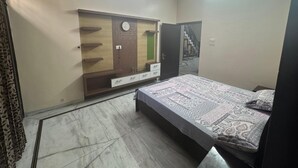 A bedroom with a bed, a wardrobe, a ceiling fan, and a staircase. - comfort castle (Jalandhar)
