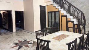 A spacious dining area with a marble floor, a star-shaped design, and a staircase with a black railing. - comfort castle (Jalandhar)