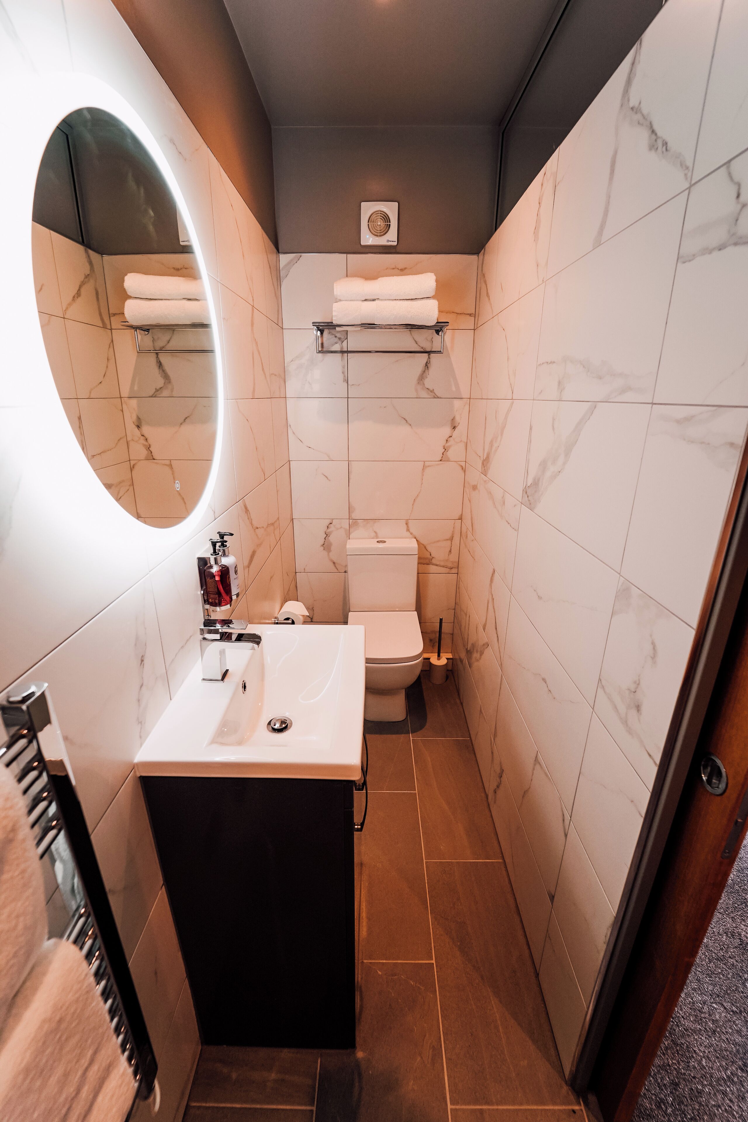 Un baño pequeño con un lavabo blanco, un inodoro y un perchero para toallas.