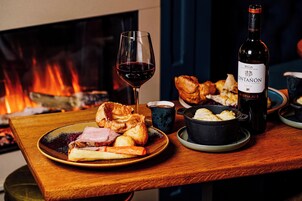 Una mesa de comedor con platos de comida, una copa de vino y una botella.