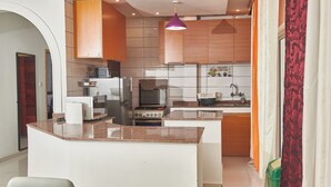 Een moderne keuken met een centraal eiland, houten kastjes en roestvrijstalen apparatuur.