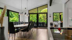 Una cocina moderna con una isla grande, sillas negras y una mesa de comedor con sillas.