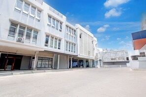 A modern building with multiple floors, large windows, and a flat roof. - Hotel O Mega Inn Guest House (Tegal)