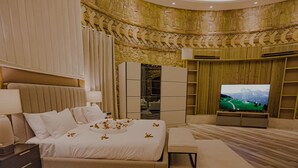 Quarto de hotel moderno com uma cama grande, televisão e guarda-roupa.
