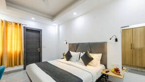 Un dormitorio moderno con una cama grande, mesitas de noche, un armario y un ventilador de techo.