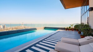 Una piscina en la azotea con vistas a la ciudad y al mar.