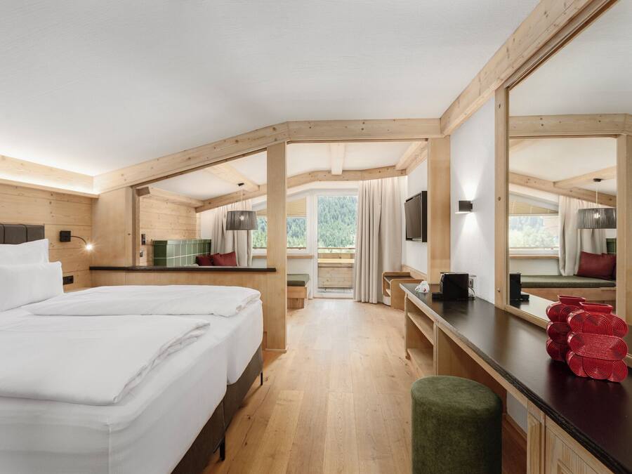 Habitación de hotel moderna con una cama grande, un escritorio y vistas al exterior.