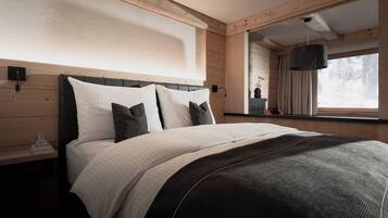 Ein Schlafzimmer mit Bett, Nachttisch und einem Vorhangfenster.
