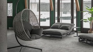 A modern interior with a hanging chair, a sofa, and a dining table. - VAYA Lechtal (Elbigenalp)