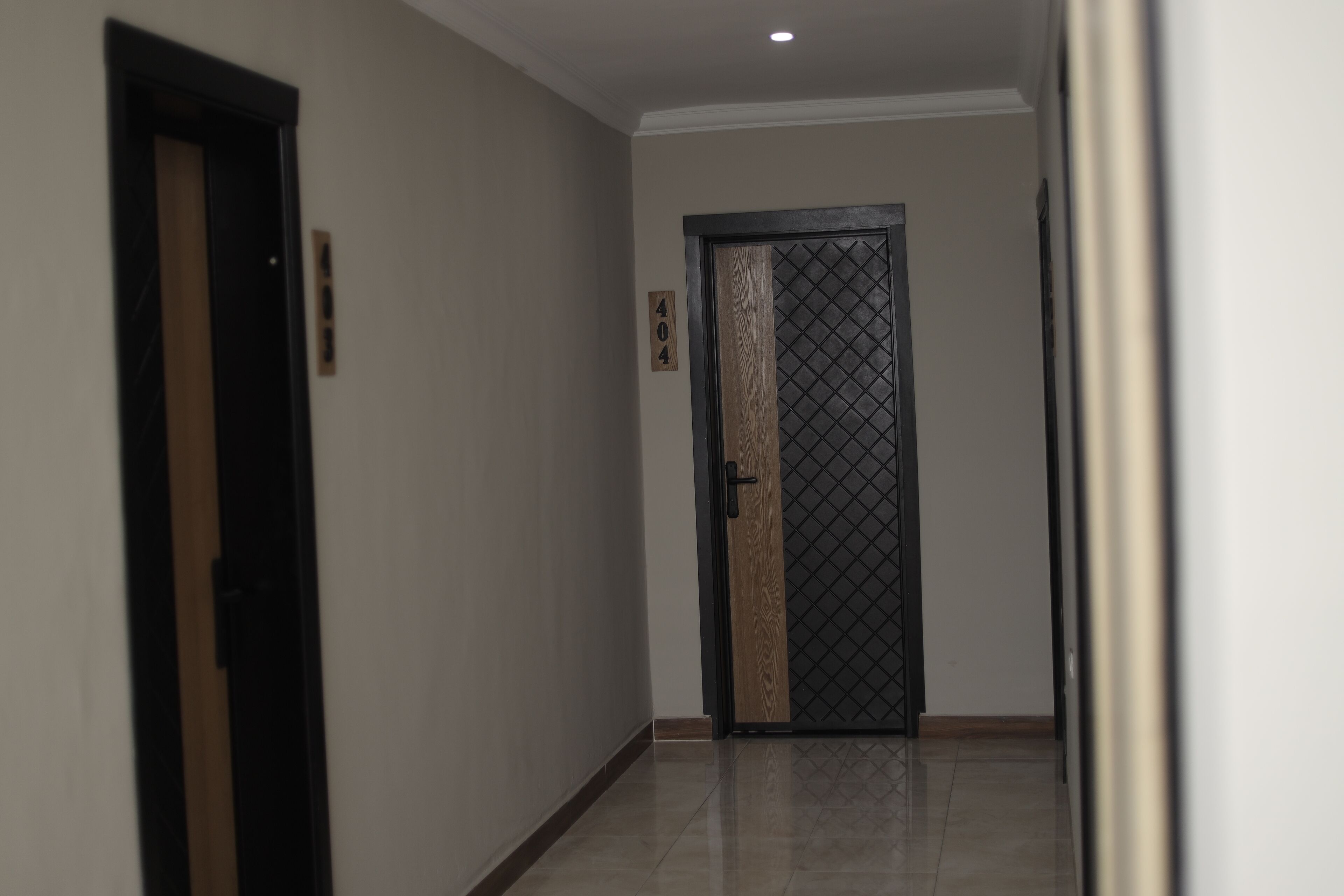 A hallway with a door marked '404' and a door with a decorative panel.