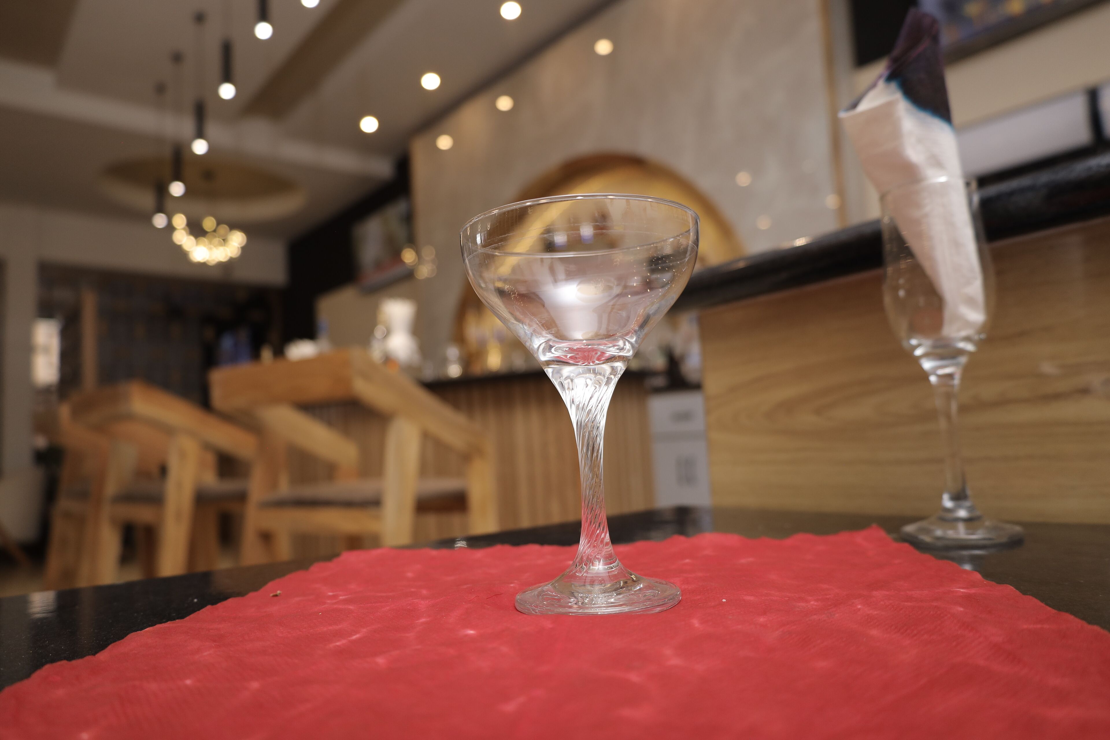 A bar area with a red tablecloth, a martini glass, and a cocktail glass.