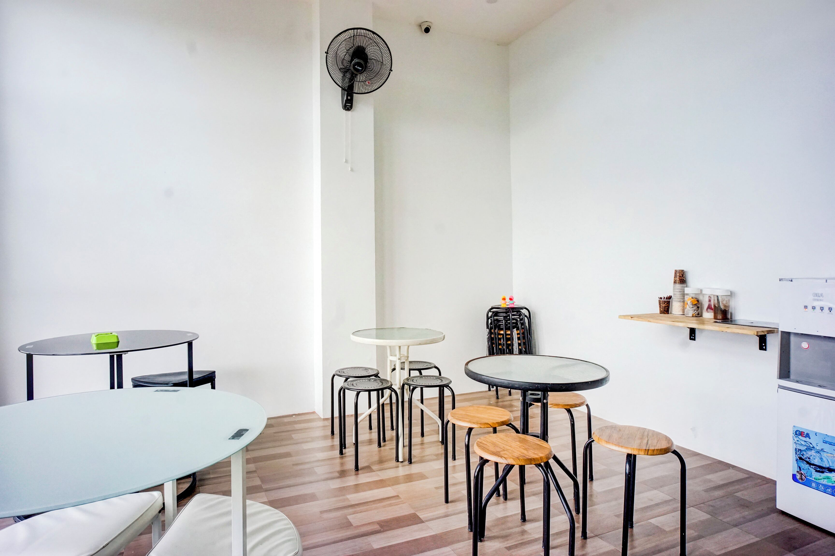 Une cuisine moderne équipée d’un réfrigérateur, d’un four à micro-ondes et d’un évier. On y trouve également plusieurs tabourets et une table avec des chaises.