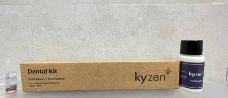 Ein Dentalset mit einer Schachtel und einer Flasche mit dem Aufdruck 'kyzen' auf einer ebenen Fläche.