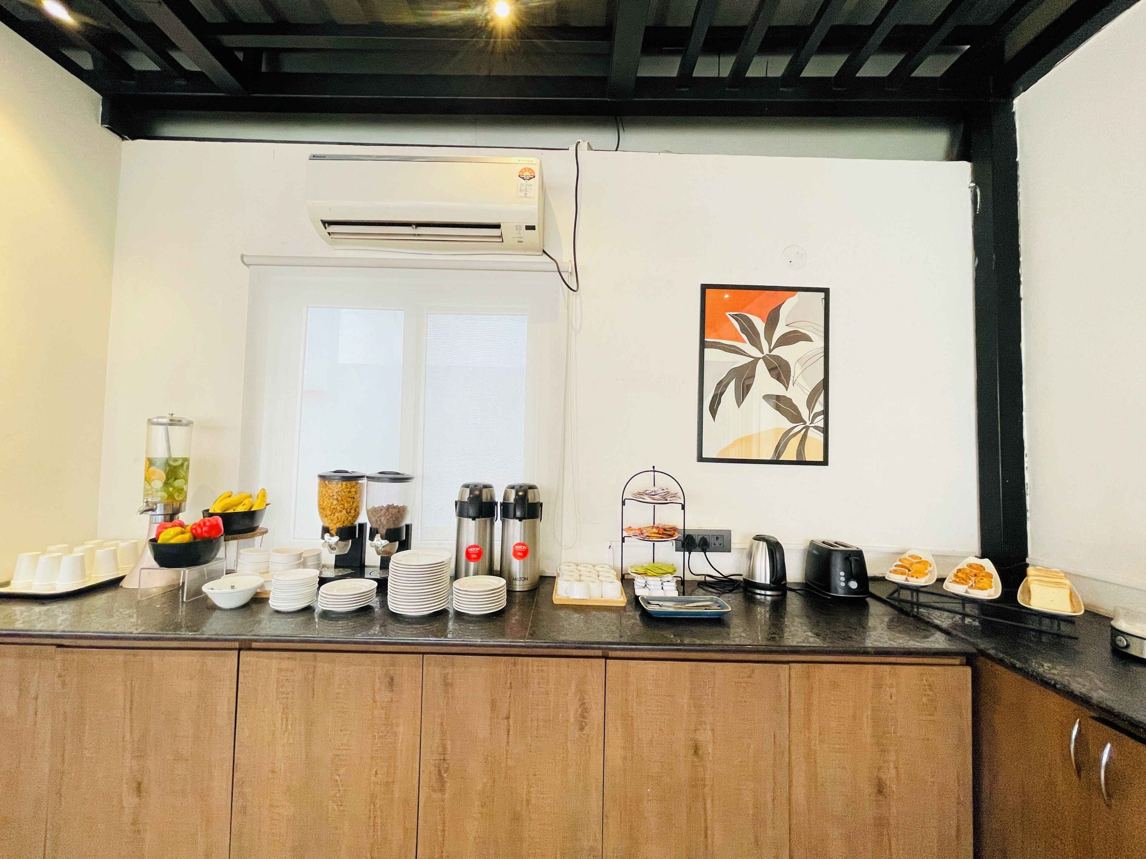 A kitchen counter with a water dispenser, fruit bowl, coffee makers, and a toaster.