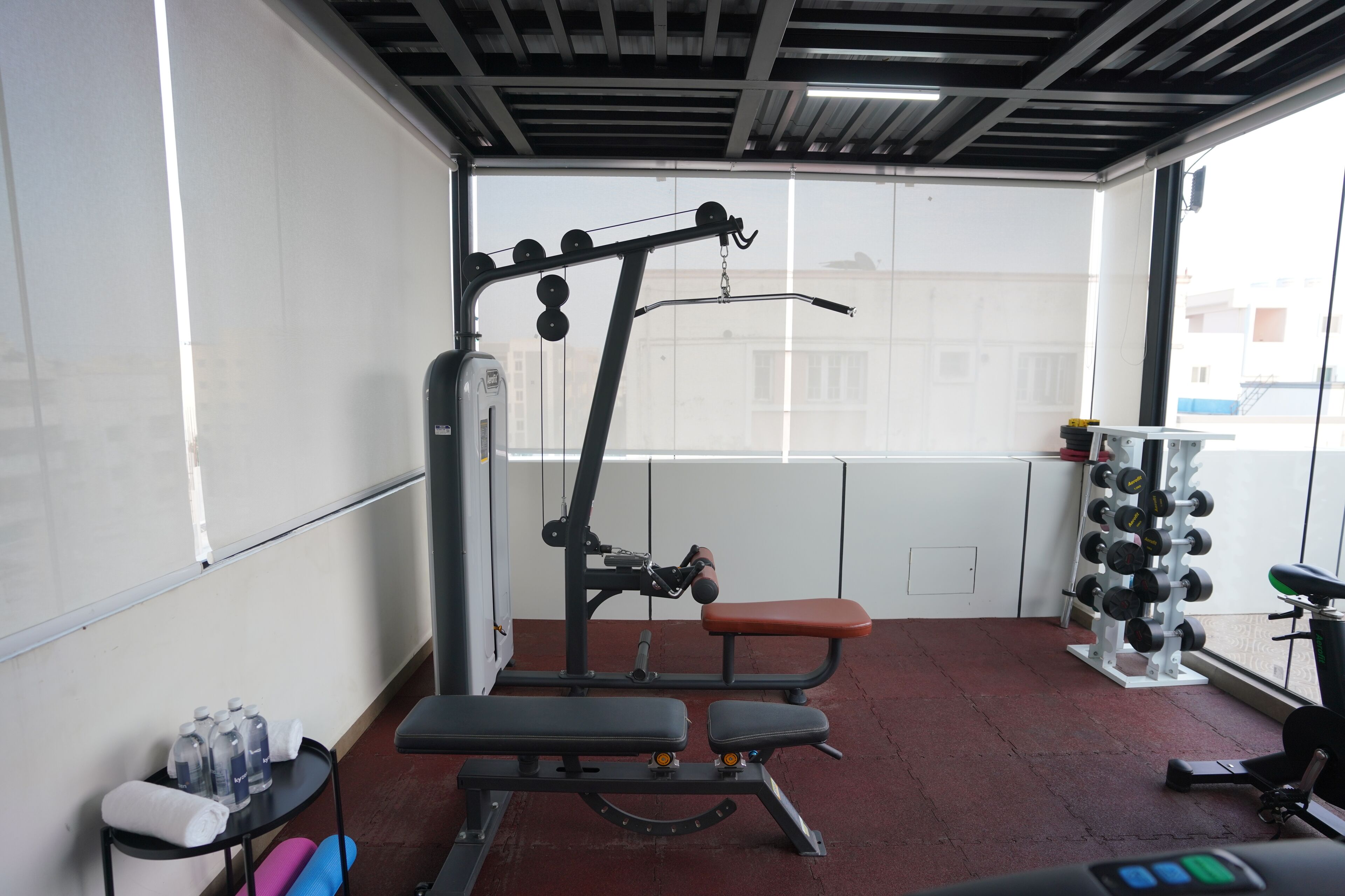 Une salle de sport équipée de matériel d’exercice, d’un banc et d’un porte-haltères.