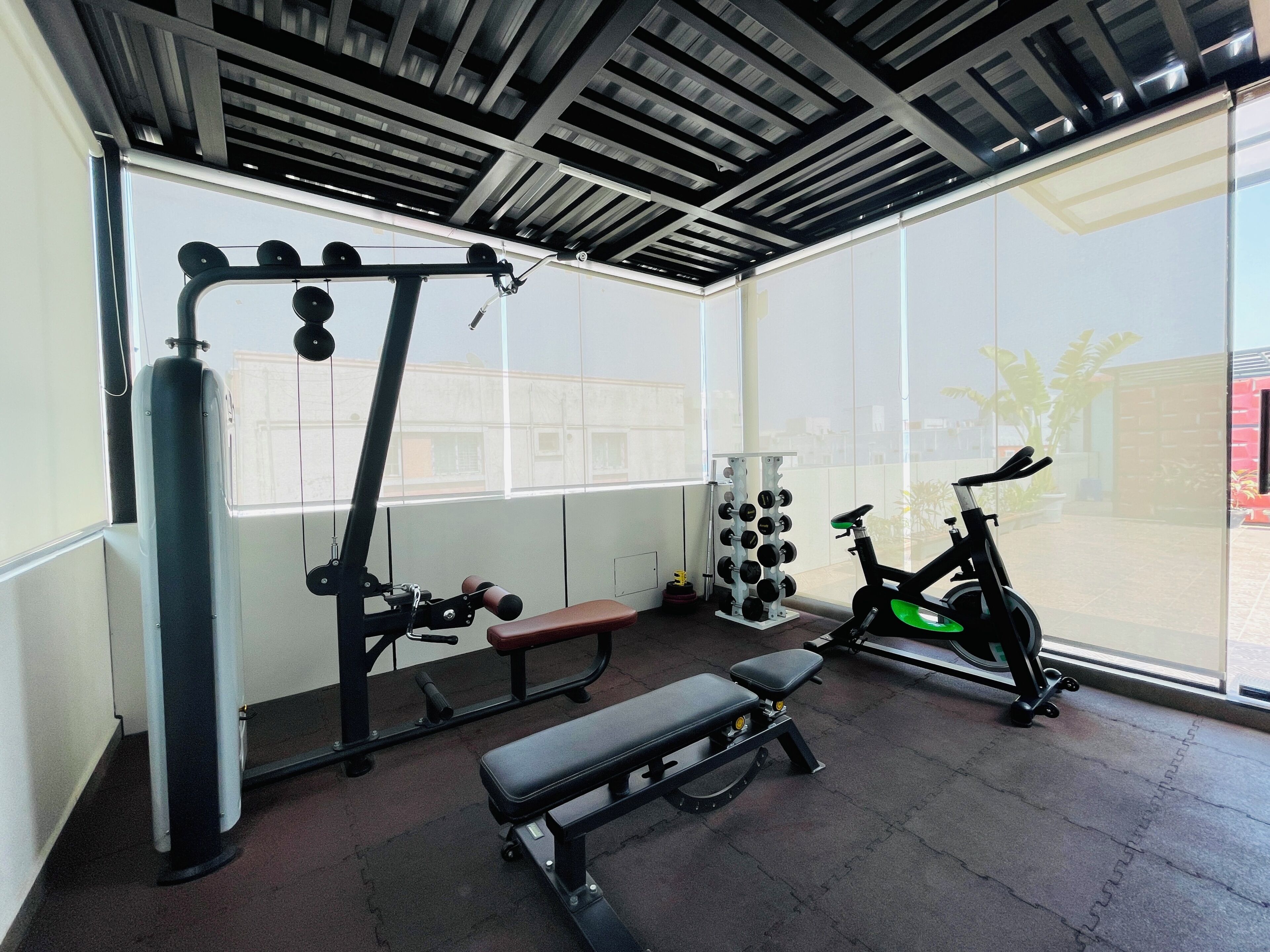 Une salle de sport équipée de matériel d’exercice, d’un banc et d’un vélo.