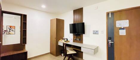 Ein Hotelzimmer mit Schreibtisch, Stuhl, Fernseher und einer Tür mit einem Hinweis.