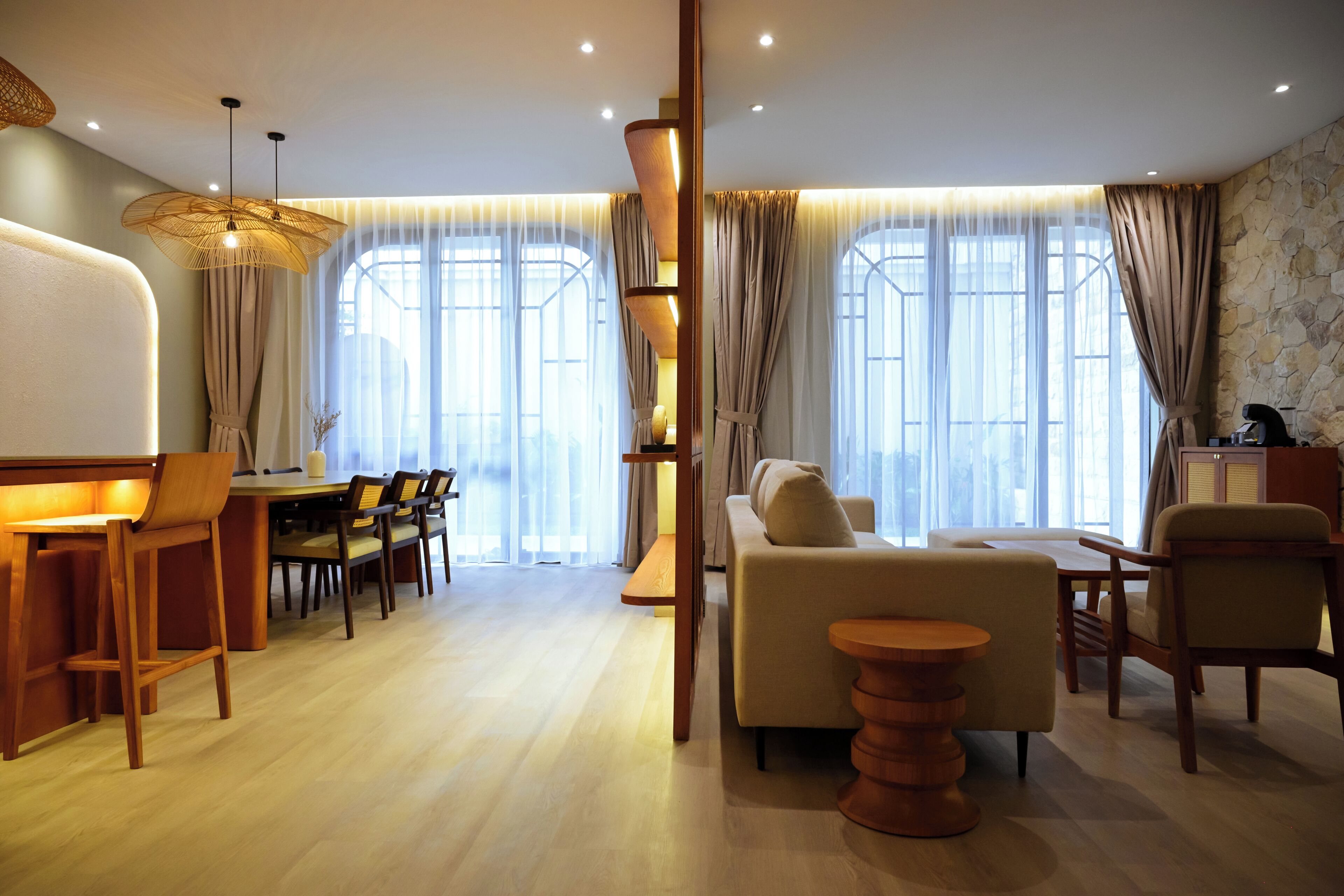 A modern living room with a sofa, chairs, a dining table, and a coffee table.