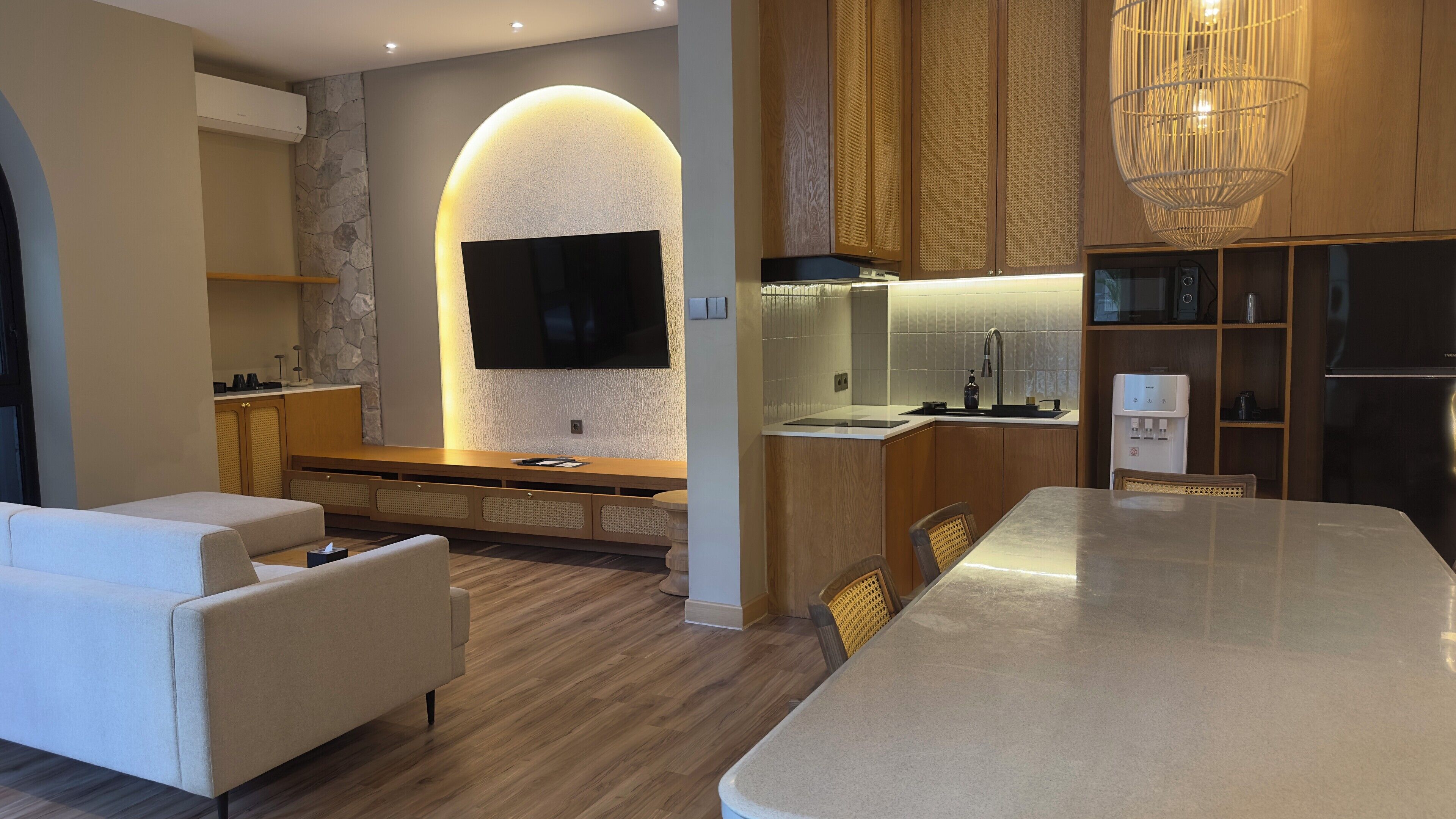 A modern kitchen with a built-in oven, a sink, and a large island.