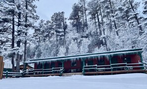 A cabin with a red exterior, green railings, and icicles hanging from the roof. - Room 16 – Classic Comfort (Lead)