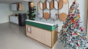 Ein Empfangsbereich mit einem Holzbüro, einem Weihnachtsbaum und dekorativen Wandspiegeln.