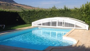 A swimming pool with a white deck and a cable running along the edge.