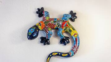 A colorful ceramic lizard sculpture on a plain wall.