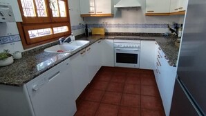 A compact kitchen with white cabinets, a built-in oven, a sink, and a tiled backsplash. - House with pool on the Costa Dorada, very close to the beach (Sant Salvador)