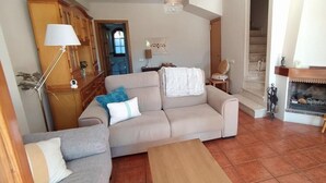 A living room with a beige sofa, a grey sofa, a wooden coffee table, a fireplace, and a television on a wooden stand. - House with pool on the Costa Dorada, very close to the beach (Sant Salvador)