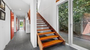 Eine moderne Treppe mit Holzboden, die zu einer Glastür führt.