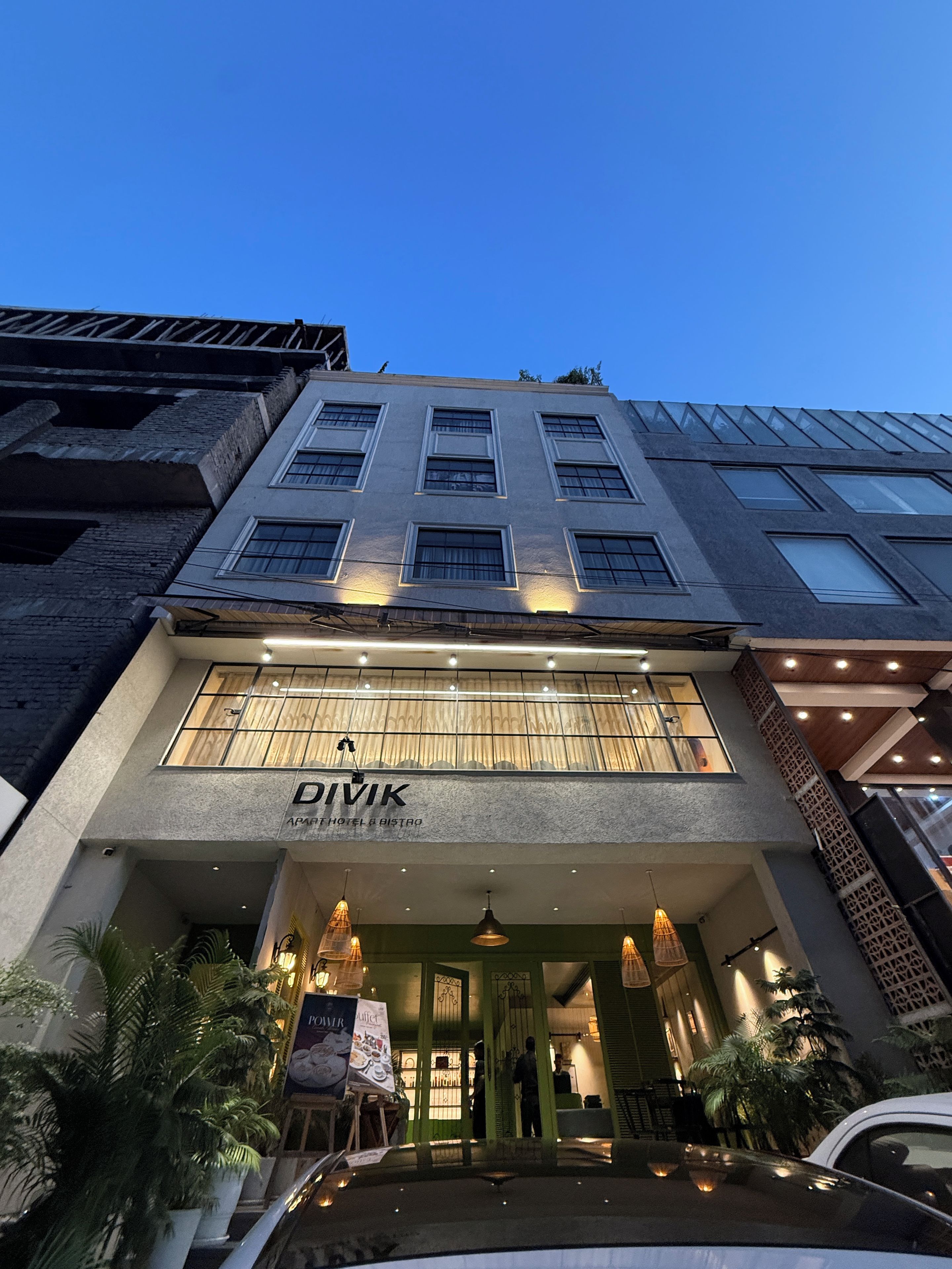 Een gebouw met een bordje waarop staat 'DIVIK APARTHOTEL & BISTRO' bij de ingang.