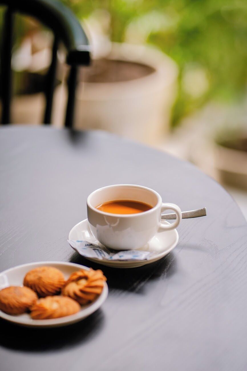 Una mesa con una taza de café y un plato de pasteles.