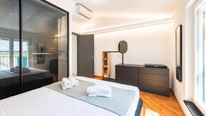 A modern hotel room with a large bed, a glass partition, a wardrobe, and a desk with a mirror. - Wonderful House In Portofino With Parking (Portofino)