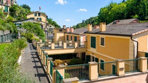 A row of terraced houses with balconies, a paved street, and lush greenery. - Wonderful House In Portofino With Parking (Portofino)