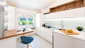 A modern kitchen with white cabinetry, a wooden countertop, a built-in oven, and a window with a view of greenery. - Wonderful House In Portofino With Parking (Portofino)