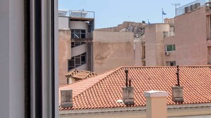 A view of buildings with red-tiled roofs and a clear sky.