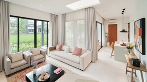 A spacious living room with a sofa, coffee table, and dining area.