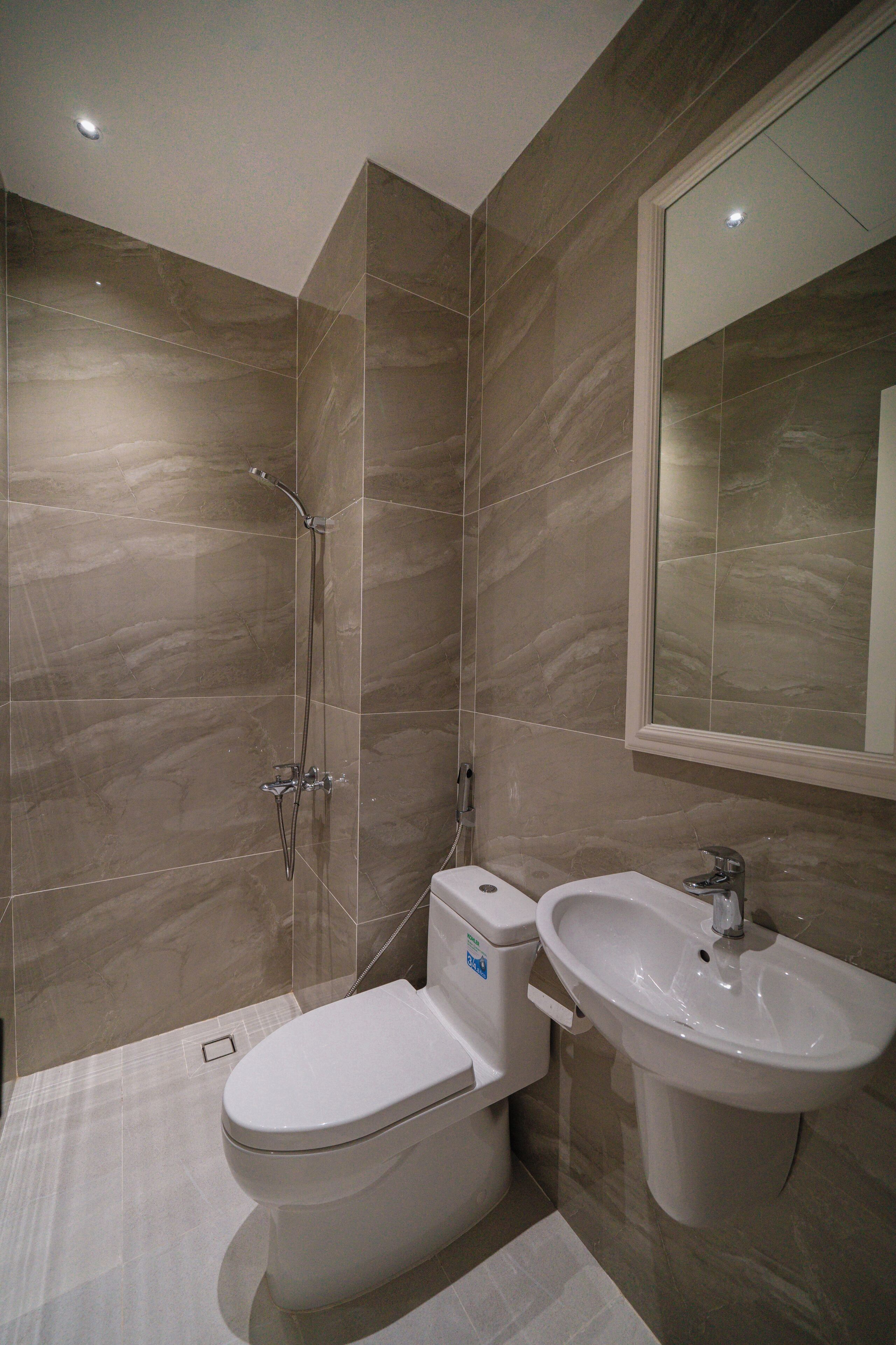 Une salle de bain moderne équipée d’une douche, de toilettes et d’un lavabo.