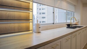 Eine moderne Küche mit großem Fenster, Holzvertäfelung und einem Einbauofen.