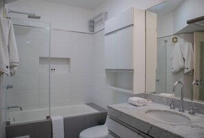 A modern bathroom with a glass-enclosed shower, a bathtub, a sink with a marble countertop, and a toilet. - Wonderful 1BR with Great Deco in Miraflores (Miraflores)