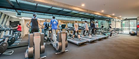 Una palestra moderna con tapis roulant, cyclette e macchinari per l'allenamento con i pesi.