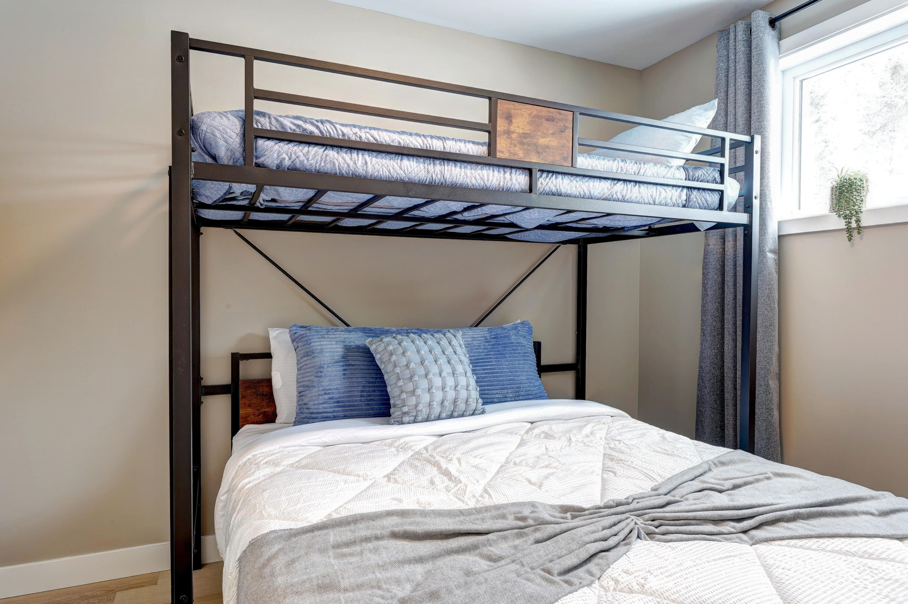 Uma cama beliche com uma cama inferior e uma janela com cortinas.