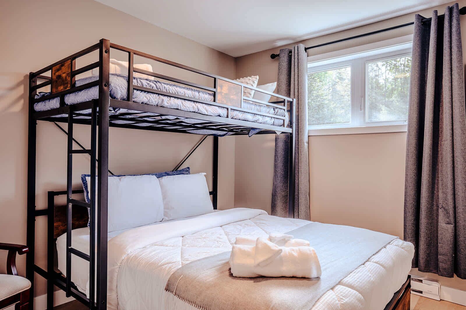 Dormitorio con literas, ventana y cortinas.